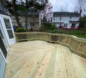 A newly constructed, custom-shaped wooden deck with secure railings, designed and installed by a trusted deck builder Gaithersburg MD.