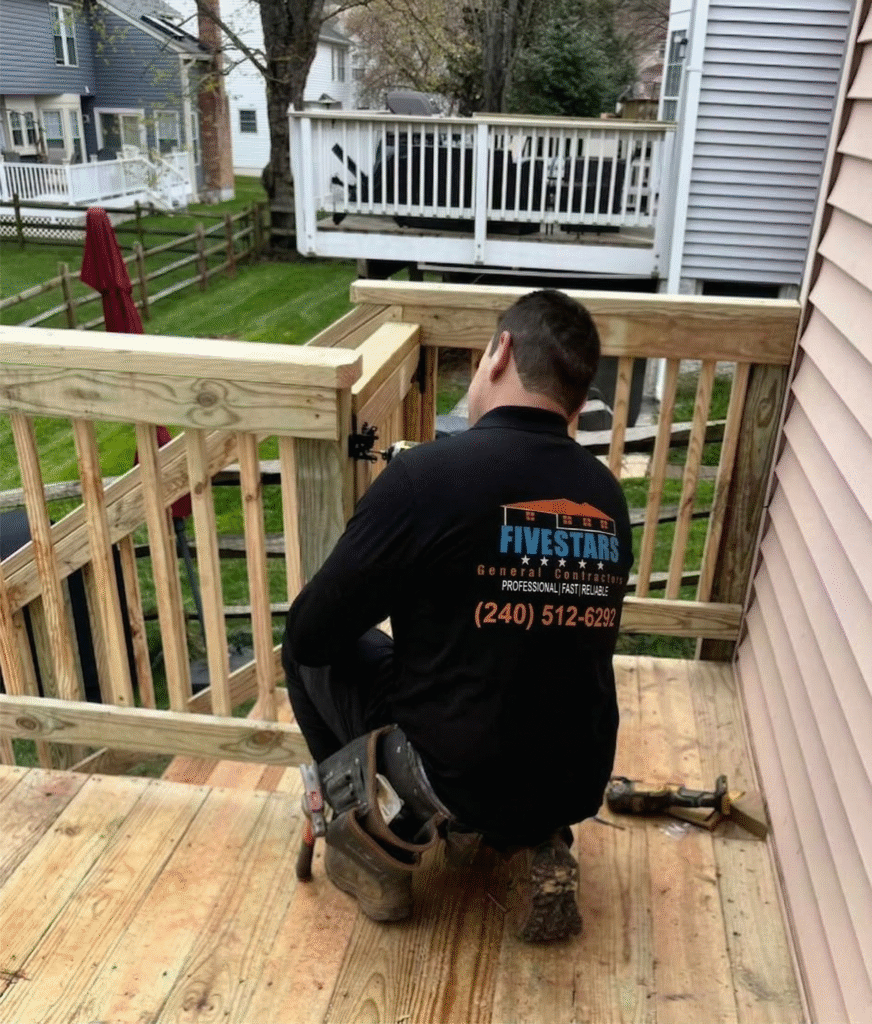 A Five Stars Contractors team member meticulously installing a safety gate on a new wooden deck, highlighting the attention to detail of your local deck builder Gaithersburg MD.