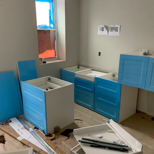 Five Stars Contractors LLC assembling bright blue and white cabinetry during an ongoing custom closet installation Maryland project.