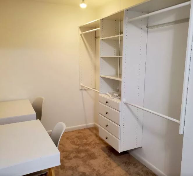 A bright and organized white shelving system, showcasing a space-saving custom closet installation Maryland for a narrow room.