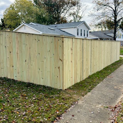 A clean and visually appealing wood dog-ear picket fence, providing a cost-effective and classic option for Modern Privacy Fencing Maryland in residential neighborhoods.