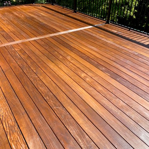 A wooden deck surface undergoing professional restoration and weatherproofing by an expert deck builder Gaithersburg MD.