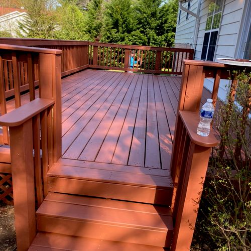 A beautiful, newly stained custom deck with stairs, built by a professional deck builder Gaithersburg MD.