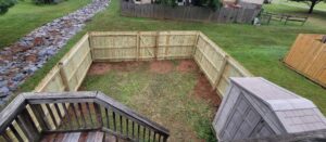 A freshly built pressure-treated wood fence enclosing a residential backyard, an economical and classic option for the best fence material for Maryland 2026.